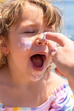 Çocuğun yüzünde güneş kremi var. Seçici odaklanma. çocuk.