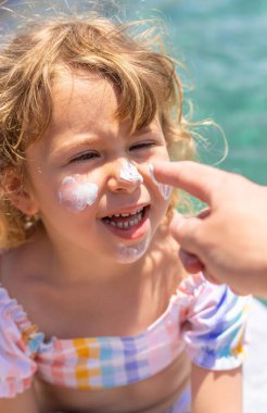 Çocuğun yüzünde güneş kremi var. Seçici odaklanma. çocuk.