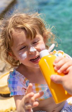 Çocuğun yüzünde güneş kremi var. Seçici odaklanma. çocuk.