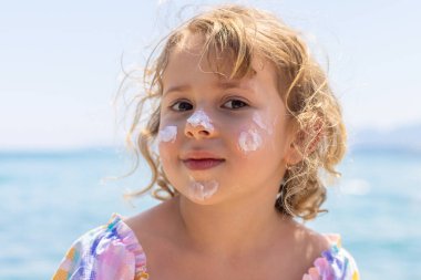 Çocuğun yüzünde güneş kremi var. Seçici odaklanma. çocuk.