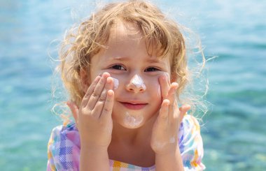 Çocuğun yüzünde güneş kremi var. Seçici odaklanma. çocuk.