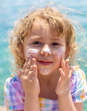 Çocuğun yüzünde güneş kremi var. Seçici odaklanma. çocuk.