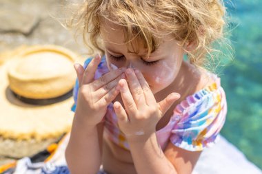 Çocuğun yüzünde güneş kremi var. Seçici odaklanma. çocuk.
