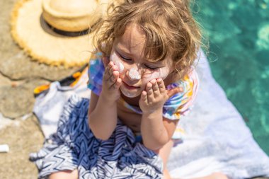 Çocuğun yüzünde güneş kremi var. Seçici odaklanma. çocuk.