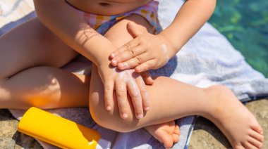 Çocuğun ellerinde güneş kremi var. Seçici odaklanma. çocuk.