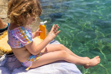 Çocuğun ellerinde güneş kremi var. Seçici odaklanma. çocuk.