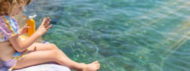 Çocuğun ellerinde güneş kremi var. Seçici odaklanma. çocuk.