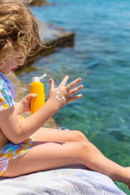 Çocuğun ellerinde güneş kremi var. Seçici odaklanma. çocuk.