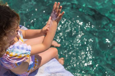 Çocuğun ellerinde güneş kremi var. Seçici odaklanma. çocuk.