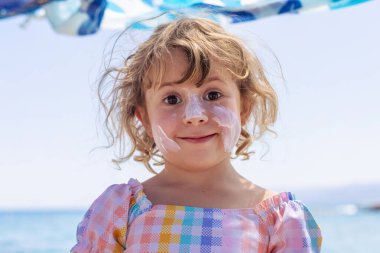 Çocuğun yüzünde güneş kremi var. Seçici odaklanma. çocuk.