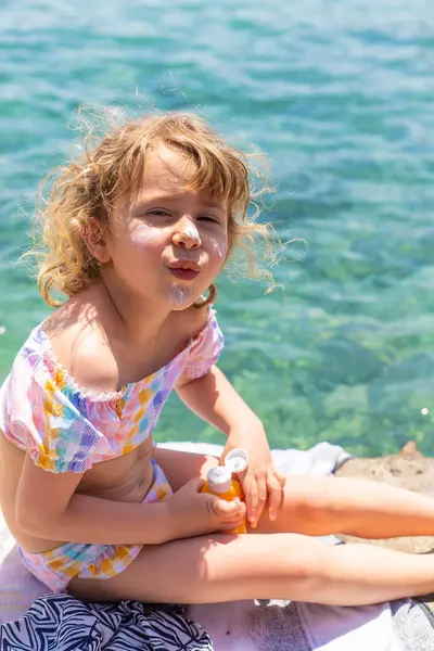 Çocuğun yüzünde güneş kremi var. Seçici odaklanma. çocuk.