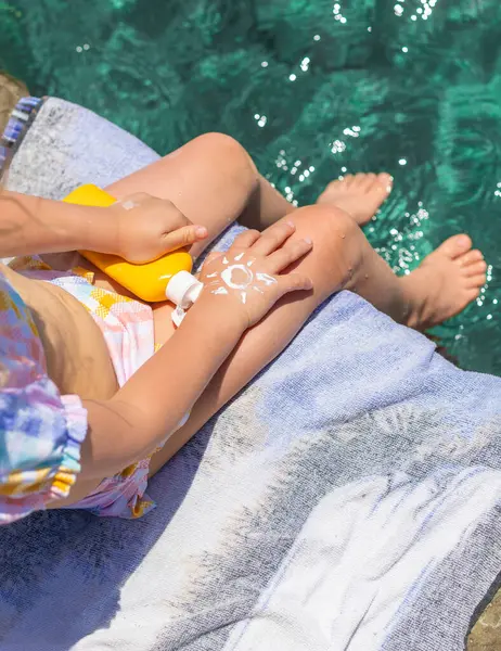 Çocuğun ellerinde güneş kremi var. Seçici odaklanma. çocuk.