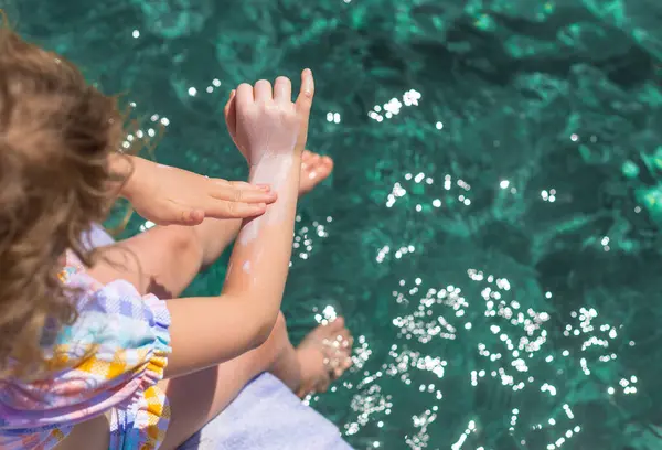 Çocuğun ellerinde güneş kremi var. Seçici odaklanma. çocuk.