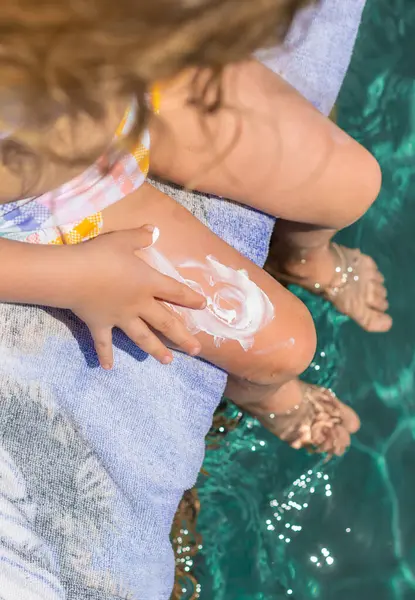 Çocuğun bacaklarında güneş kremi var. Seçici odaklanma. çocuk.