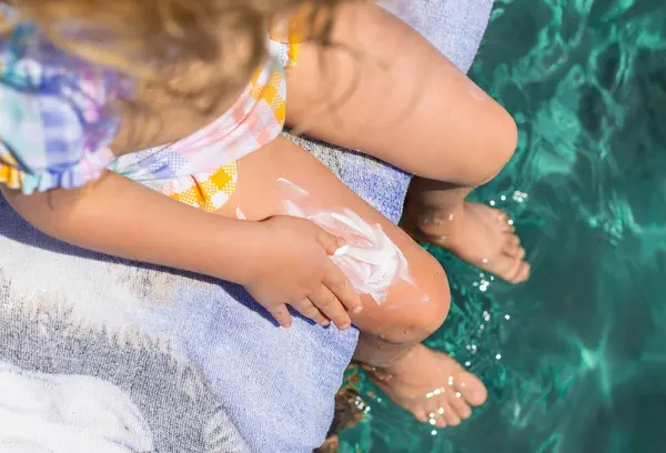 Çocuğun bacaklarında güneş kremi var. Seçici odaklanma. çocuk.