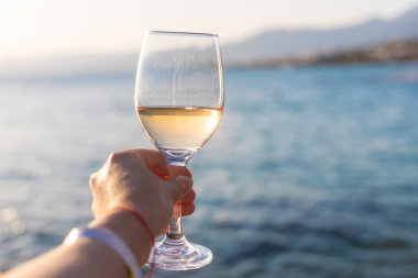 Denize karşı kadının ellerinde şarap. Seçici odaklanma. iç.