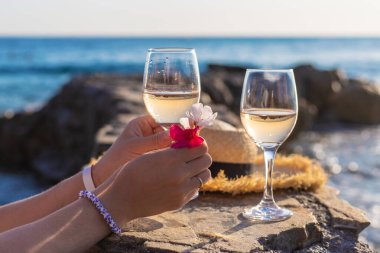 Denize karşı kadının ellerinde şarap. Seçici odaklanma. iç.