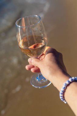 Denize karşı kadının ellerinde şarap. Seçici odaklanma. iç.