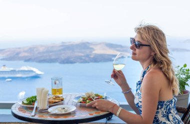 Yunanistan 'da bir restoranda Yunan salatası ve şarap. Seçici odaklanma. Kadın.