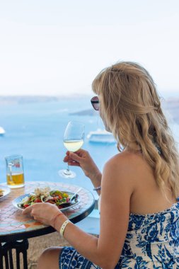 Yunanistan 'da bir restoranda Yunan salatası ve şarap. Seçici odaklanma. Kadın.