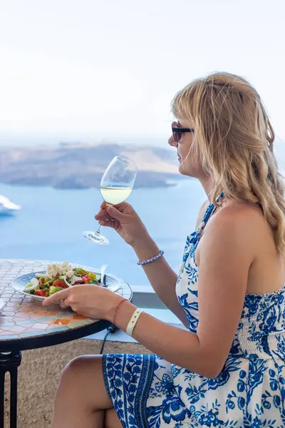 Yunanistan 'da bir restoranda Yunan salatası ve şarap. Seçici odaklanma. Kadın.