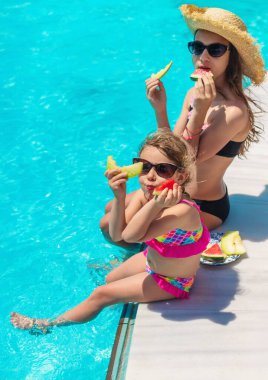 Çocuklar havuzun yanında karpuz yerler. Seçici odaklanma. Yiyecek..