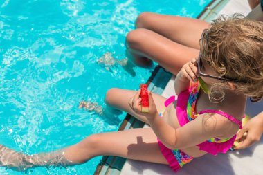 Çocuklar havuzun yanında karpuz yerler. Seçici odaklanma. Yiyecek..