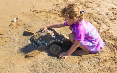 Çocuklar kumsalda kumla oynuyorlar. Seçici odaklanma. deniz.