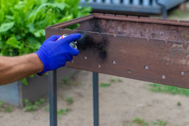 Barbeküyü ateşe dayanıklı boyayla boya. Seçici odaklanma. Doğa.