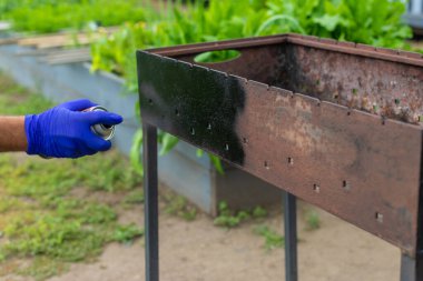 Barbeküyü ateşe dayanıklı boyayla boya. Seçici odaklanma. Doğa.