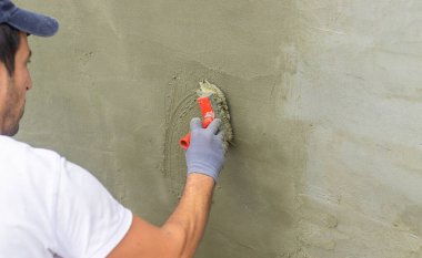 Bir zanaatkar beton bir duvar inşa eder. Seçici odaklanma. insanlar.