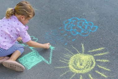 Çocuklar asfalta tebeşirle resim çiziyor. Seçici odaklanma. Çocuk.