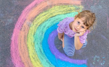 Çocuklar asfalta tebeşirle resim çiziyor. Seçici odaklanma. Çocuk.