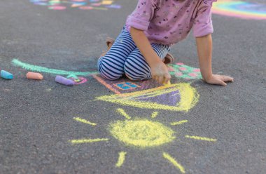 Çocuklar asfalta tebeşirle resim çiziyor. Seçici odaklanma. Çocuk.