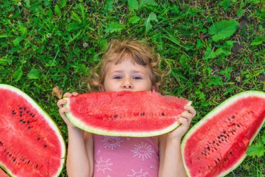 Bir çocuk parkta bir karpuz yiyor. Seçici odaklanma. Çocuk.