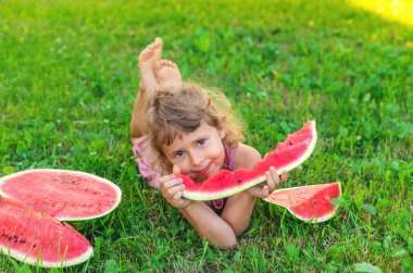 Bir çocuk parkta bir karpuz yiyor. Seçici odaklanma. Çocuk.