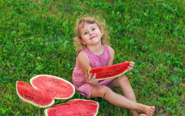 Bir çocuk parkta bir karpuz yiyor. Seçici odaklanma. Çocuk.