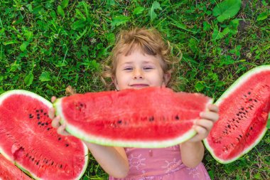 Bir çocuk parkta bir karpuz yiyor. Seçici odaklanma. Çocuk.