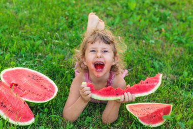 Bir çocuk parkta bir karpuz yiyor. Seçici odaklanma. Çocuk.
