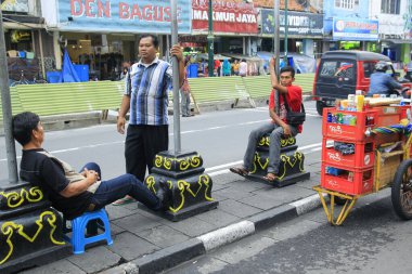 Yogyakarta, Endonezya, Bölüm 23, 2016. Tüccarlar ve insanlar Malioboro caddesinde gevşek sohbet ederek zaman geçirirler..