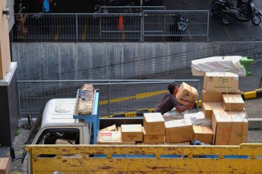 Yogyakarta, Endonezya, 17 Mart 2023. Kamyona yüklenmiş kutuları toplayan bir işçi..