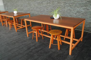 Masalar ve sandalyeler bir restoranın terasında düzgünce düzenlenir..