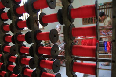 Yogyakarta, Endonezya, 26 Ekim 2015. Kırmızı iplikler yerel tekstil endüstrisinde düzgün bir şekilde düzenlenir..