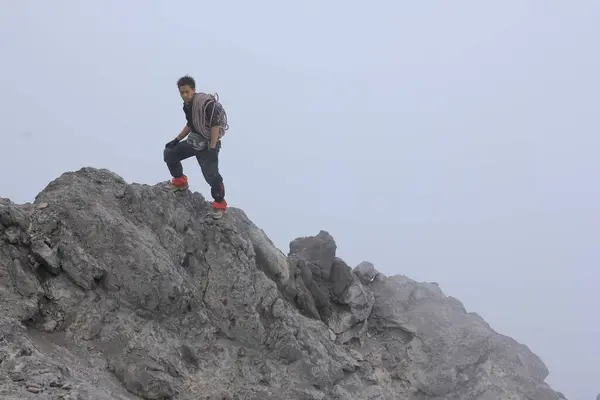 Boyolali, Endonezya, 25 Ekim 2014. Bir dağcı, Merapi zirvesinin en yüksek noktası olan volkanik kayanın üzerinde duruyor..
