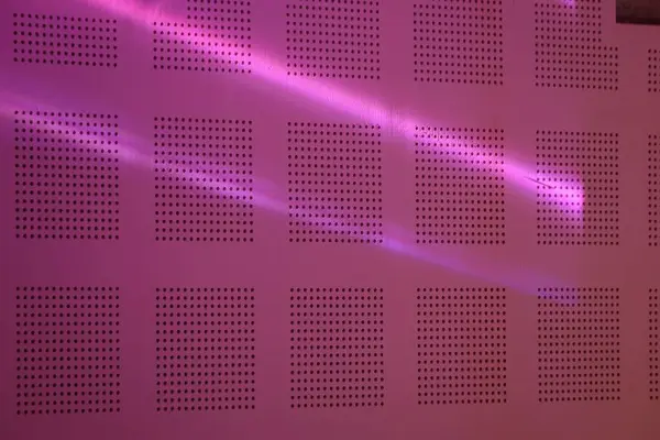 stock image A dampening wall with a pink light bias in a performance space