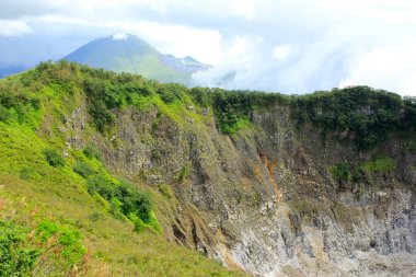 Crater wall at the top of Mount Mahawu with Mount Lokon in the background, Tomohon, North Sulawesi.