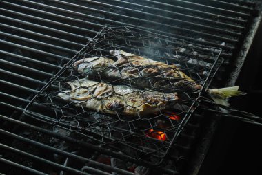 Izgarada kızartılmış balık, siyah kabuklu..