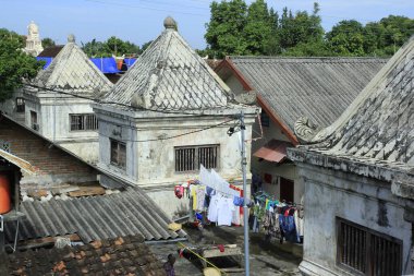 Yöre sakinleri, Yogyakarta Sari Sari Sarayı 'nın önemli bir simgesi haline gelen kültür mirası bölgesinde giysilerini asıyorlar..