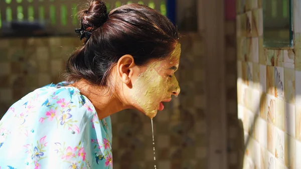 漂亮的女人在使用了面部面具后 正在浴室里洗脸 在家里 女孩站在镜子前 脸上喷水 泥面罩或自制的Multani Mitti面罩 — 图库照片