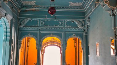 Udaipur 'un şehir sarayındaki güzel açık mavi renkli odalar. Rajasthan, Hindistan. Şehir Sarayı 'nın renkli iç manzarası. Saray lambasının içinde, yelpaze ve çerçeveler
